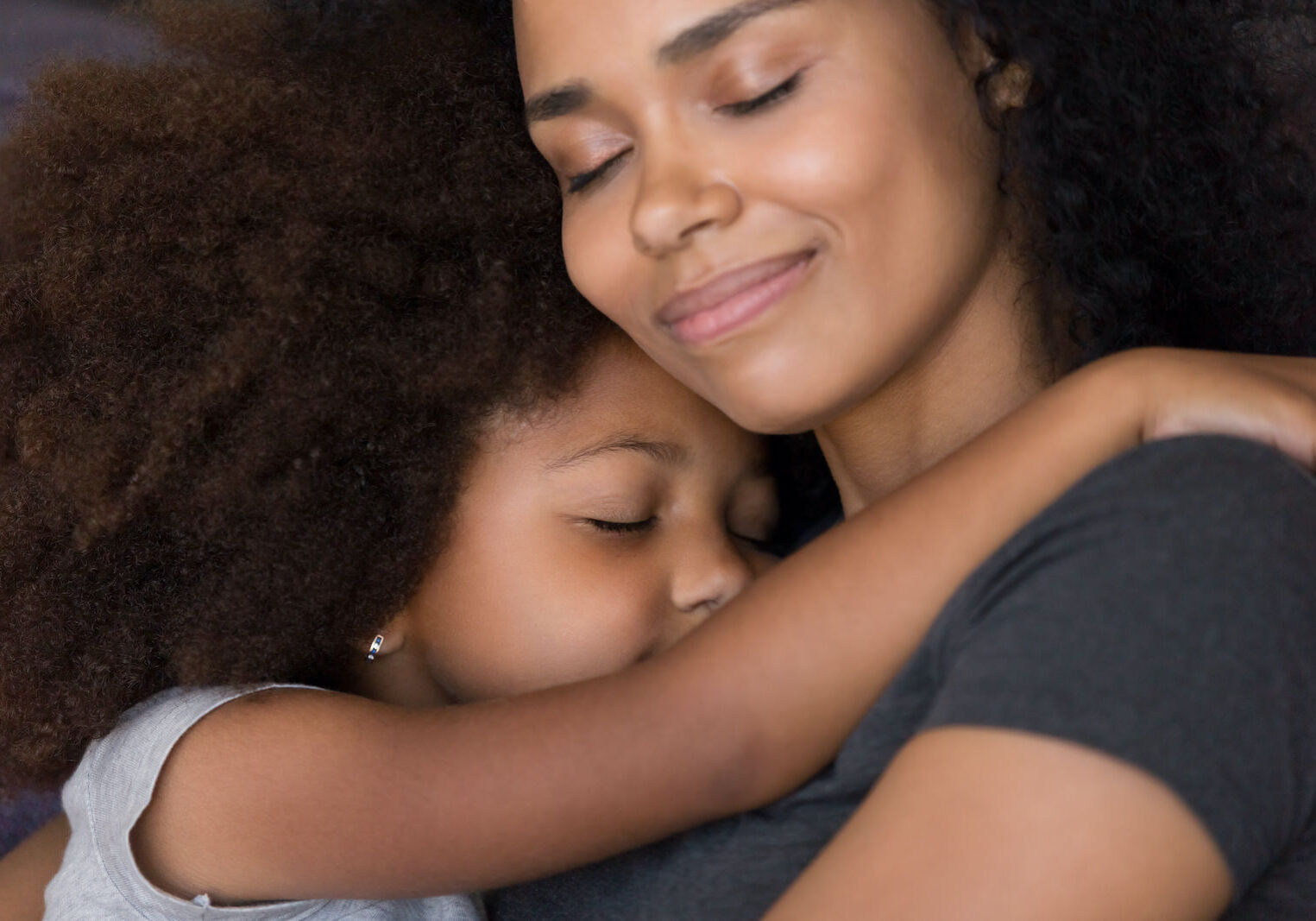 Loving single black mother hugs cute daughter feel tenderness connection, happy african mum caressing embracing little girl, mommy kid cuddle, warm relationships, child custody, foster care concept