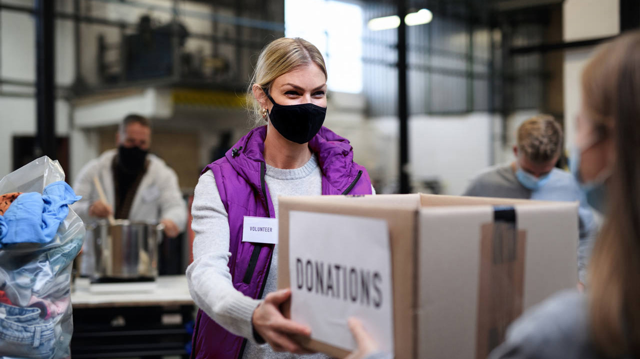 Volunteers working with food and clothes in community charity do